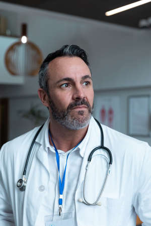Portrait of caucasian male doctor with stethoscope wearing lab coat in hospital. medicine, health...