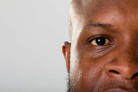 Close up of eye of african american businessman against grey background. business and professionalism conceptの写真素材