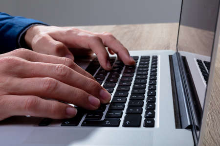 Midsection of caucasian businessman typing on keyboard, isolated on grey background. business...