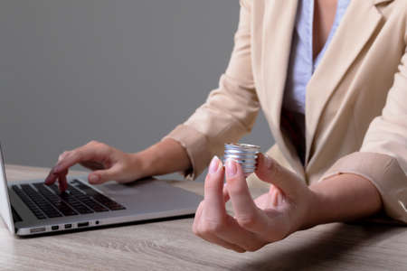 Midsection of caucasian businesswoman holding base of light bulb, isolated on grey background....