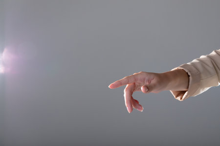 Midsection of caucasian businesswoman pointing with her finger, isolated on grey background. business, technology, communication and growth concept.の写真素材