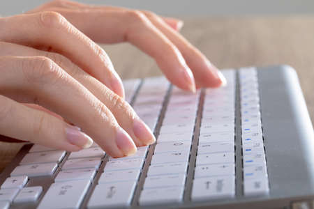 Close up of caucasian businesswoman typing on keyboard, isolated on grey background. business,...