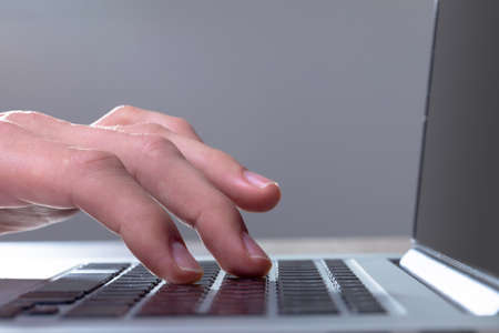 Close up of caucasian businessman typing on keyboard, isolated on grey background. business...