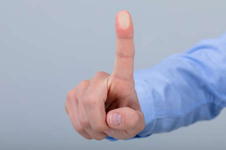 Midsection of caucasian businessman touching virtual interface, isolated on grey background. business technology, communication and growth concept.の写真素材