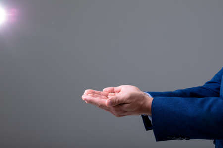 Midsection of caucasian businessman showing his hands, isolated on grey background. business technology, communication and growth concept.の写真素材