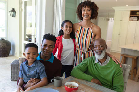 Portrait of smiling african american multi generation family sitting at table during breakfast....