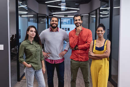 Portrait of diverse group of creative colleagues looking at camera and smiling. modern office of a...