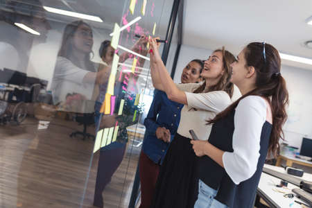 Diverse group of creative colleagues discussing work and brainstorming at meeting. modern office of...