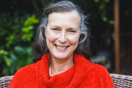 Portrait of happy senior caucasian woman looking to camera and smiling in garden. retirement...