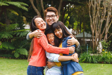 Portrait of happy asian parents, son and daughter smiling outdoors in garden. family enjoying leisure time together at home.の写真素材