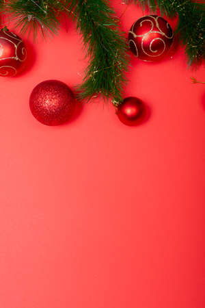 Composition of garland with baubles and copy space on red background. christmas, tradition and celebration concept.の写真素材
