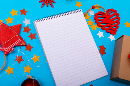 Composition of notebook with copy space and christmas decorations on blue background. christmas,...