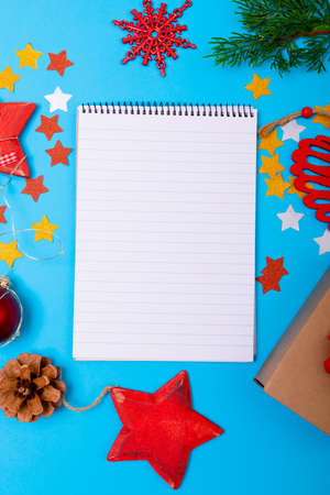 Composition of notebook with copy space and christmas decorations on blue background. christmas, tradition and celebration concept.の写真素材