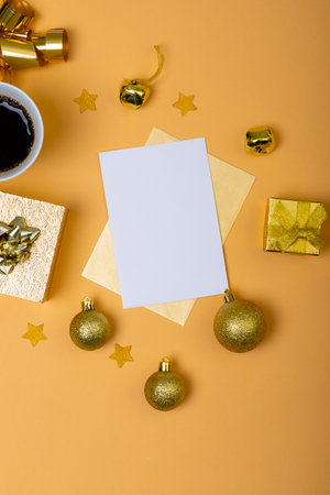 Composition of white card with copy space and christmas decorations with coffee on yellow background. christmas, tradition and celebration concept.の写真素材