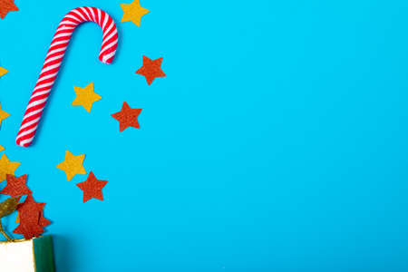 Composition of christmas decorations with candy cane and copy space on blue background. christmas,...