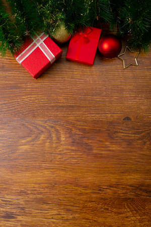 Composition of christmas decorations with presents, baubles and copy space on wooden background. christmas, tradition and celebration concept.の写真素材