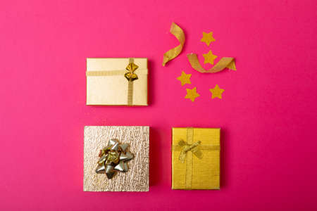 Composition of christmas decorations with presents and stars on pink background. christmas,...