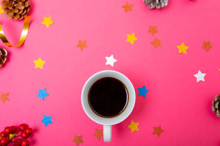 Composition of christmas decorations with pine cones, stars and coffee on pink background. christmas, tradition and celebration concept.の写真素材