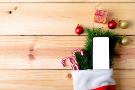 Composition of smartphone with copy space and christmas decorations on wooden background. christmas,...