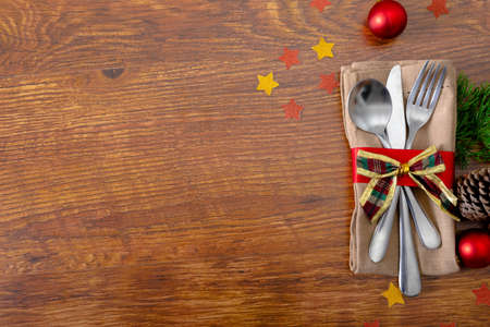 Composition of christmas decorations with cutlery and copy space on wooden background. christmas, tradition and celebration concept.の写真素材