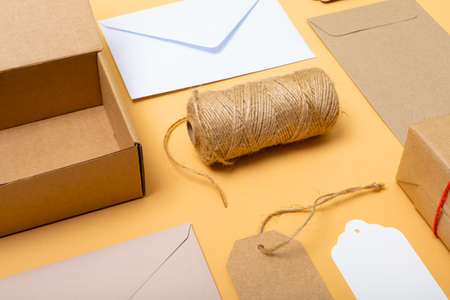 Composition of boxes, envelopes and gift tags on yellow background. christmas, gifts, tradition and celebration concept.の写真素材