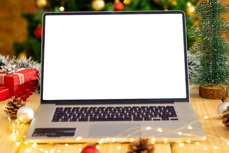 Composition of laptop with copy space on wooden table with christmas decorations. christmas, communication, tradition and celebration concept.の写真素材