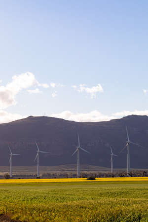 General view of wind turbines in countryside landscape with cloudy sky. environment, sustainability,...