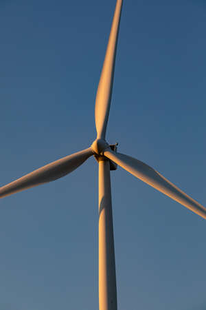 Close up of wind turbine in countryside landscape with cloudless sky. environment, sustainability,...