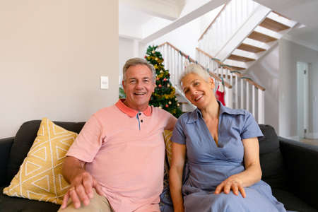 Happy caucasian senior couple having video call, looking at camera at christmas time. christmas,...