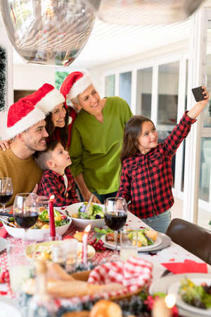 Caucasian multi generation family wearing santa hats taking selfie at christmas time. family...