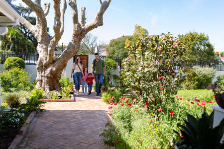 Happy caucasian family returning home after school and work. family time, having fun together at home.の写真素材