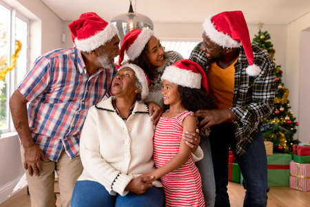Happy multi generation family wearing santa hats, taking photo. family christmas time and festivity together at home.の写真素材