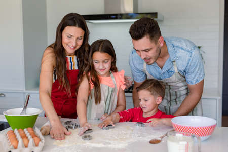 Happy caucasian family baking together, making cookies in kitchen. family time, having fun together...