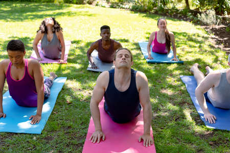 Group of diverse female and male people practicing yoga outdoors. fitness and healthy, active lifestyle.の写真素材