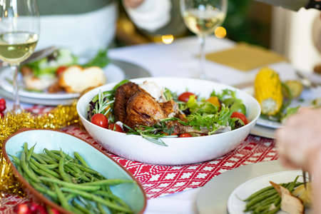 Hands of caucasian man and diverse dishes on christmas table. christmas, festivity, tradition and celebrating at home.の写真素材
