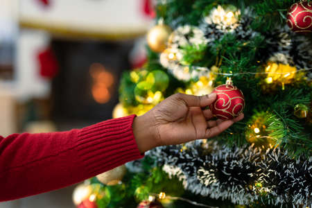 Hand of african american senior woman decorating christmas tree. retirement lifestyle and christmas...