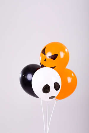 Orange, black and white halloween balloons over white background. halloween tradition and celebration concept digitally generated image.の写真素材