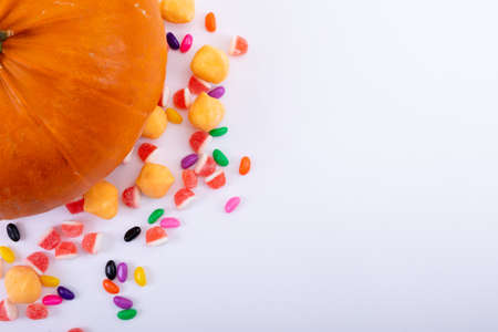 Composition of halloween pumpkin and trick or treat sweets with copy space on white background. halloween tradition and celebration concept.の写真素材