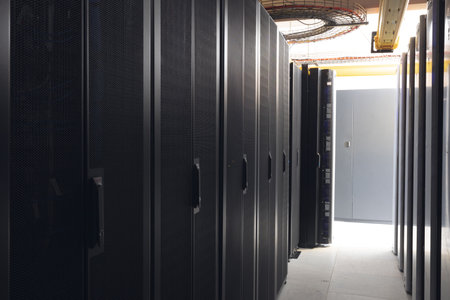 Data center with multiple rows of fully operational server racks. modern cloud computing technology...