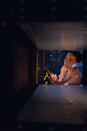 Caucasian female engineer inspecting the server in computer server room. database server management and maintenance conceptの写真素材