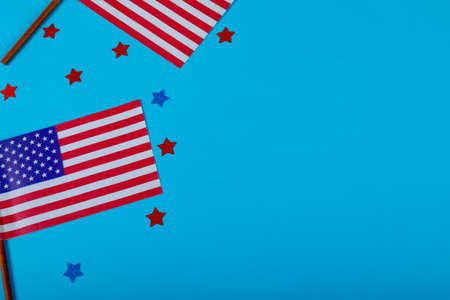 Small america flags on sticks by glitter stars by copy space over blue background. patriotism, symbol and identity.の写真素材