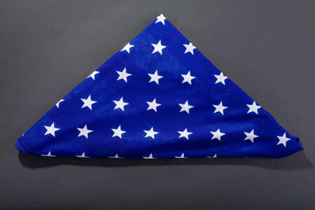 White stars on triangle shape folded america flag on black background with copy space. patriotism, symbol and identity.の写真素材