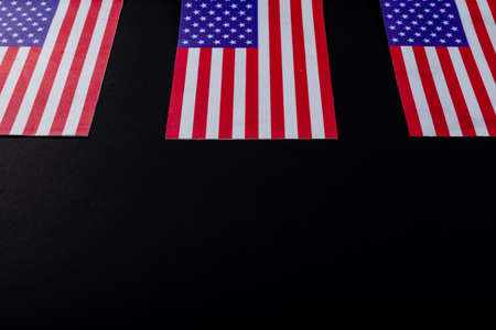 Usa flags with stars and stripes flattened by copy space over black background. patriotism, symbol and identity.の写真素材
