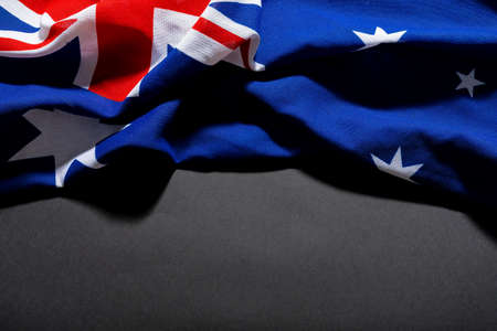 British union jack along with stars on australia flag on black table and copy space. patriotism, symbol and identity.の写真素材