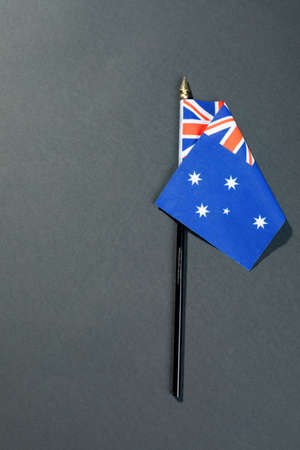 Overhead view of stars and union jack on australia flag stick by copy space over black table. patriotism, symbol and identity.の写真素材