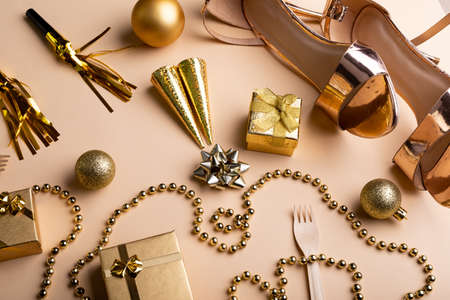 Overhead view of various christmas decorations with female footwear and necklace along with gift....