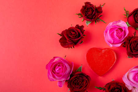 Fresh red and pink roses with heart shape with copy space on colored background. love and valentine gift.の写真素材
