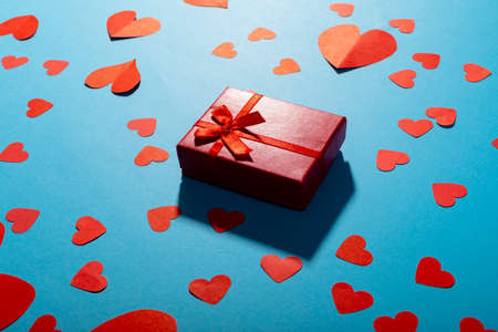 High angle view of red hearts with gift box on blue background, copy space. valentine's day, gift and love concept.の写真素材