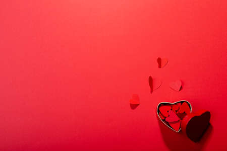 Overhead view of heart shaped decoration and gift box on red background, copy space. valentine's day and love concept.の写真素材