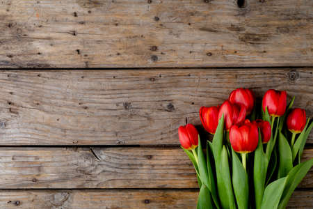 Overhead view of fresh red tulips on wooden table, copy space. valentine's day and flowers.の写真素材